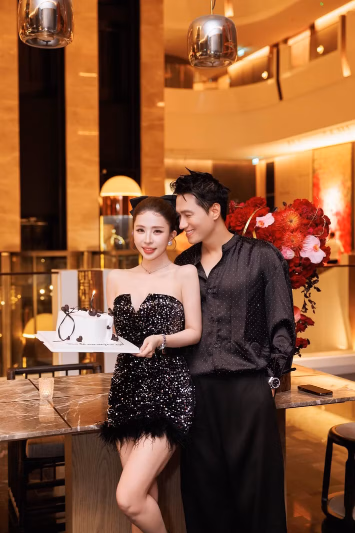 Quỳnh Nga diện váy ngắn đính sequin, trong khi Việt Anh chọn sơ mi đen. Không gian tiệc được trang trí với hoa đỏ và bánh sinh nhật. Sau khi công khai hẹn hò cách đây không lâu, cặp đôi thoải mái chia sẻ hình ảnh bên nhau. Ảnh: FB Quỳnh Nga.