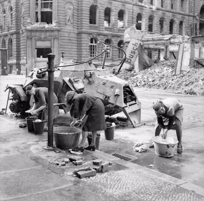Người phụ nữ Đức đang giặt quần áo bằng nước lạnh trên một con phố Berlin năm 1945.