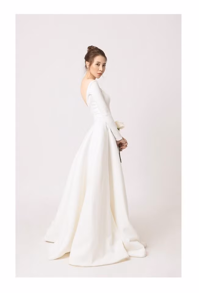 Bộ váy cưới trắng tinh khôi với phần trễ ở vai và khoe lưng trần làm tôn lên vẻ đẹp gợi cảm, nữ tính của chân dài họ Đàm.