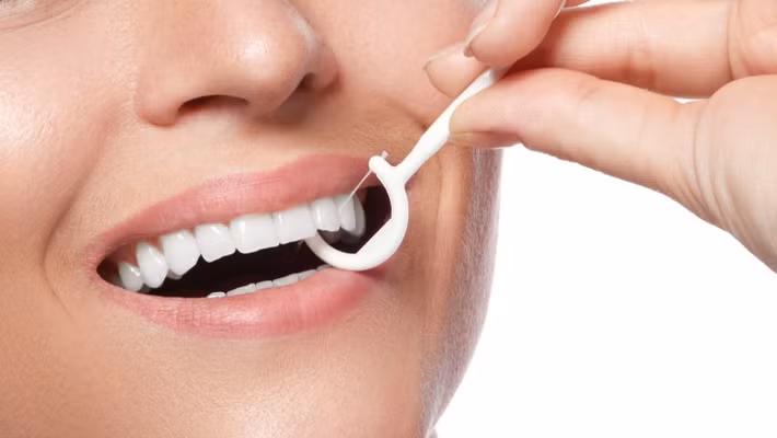 Đầu tiên, bạn lấy một đoạn chỉ nha khoa khoảng 30cm và cuốn xung quanh hai ngón tay của bạn, chỉ để lại một đoạn khoảng 5cm. Ảnh: thelist.