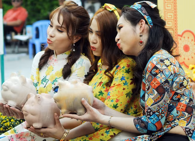 Những cô gái “check in” với những chú heo đất tại phố ông Đồ. 