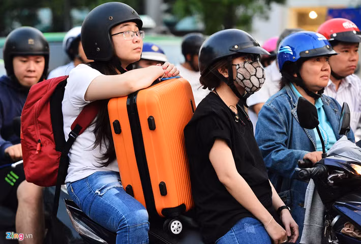 Người dân mang theo hành lý di chuyển hướng vào sân bay sốt ruột nhìn đèn tín hiệu giao thông trên đường Nguyễn Văn Trỗi.