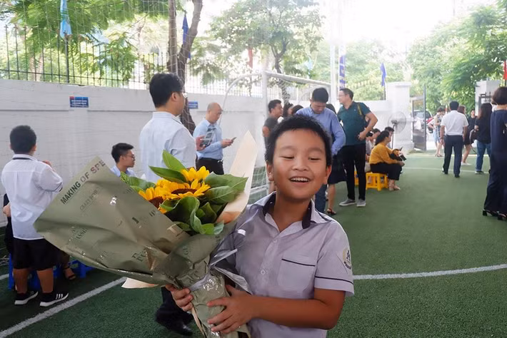 Cậu học trò cười vui khi nhận được bó hoa.