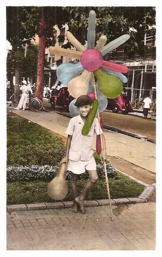Cậu bé bán bong bóng ở vườn hoa trước Nhà hát Thành phố. Ảnh: Public Domain.