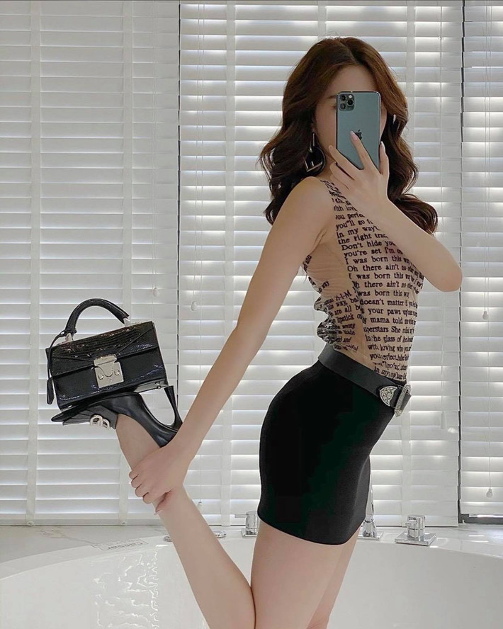 Thay vì xách hay đeo túi, Ngọc Trinh đã nghĩ ra cách pose dáng vô cùng độc lạ và khó nhằn này.