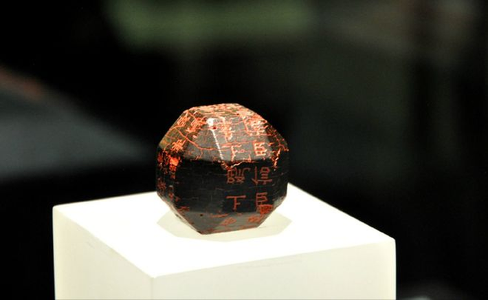 Bề ngoài của cục đá này đen sì nhưng rất sáng, và được khắc chữ màu đỏ.