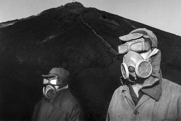 Công nhân mỏ sàng lọc đất bẩn từ quặng than đeo mặt nạ bảo vệ, tháng 11/2002. Sự đốt cháy tự phát của phế thải than không chỉ giải phóng rất nhiều nhiệt mà còn cả các loại khí như carbon monoxide, khiến người thu gom khó thở. Một số đống phế thải cũng không ổn định và có nguy cơ sụp đổ.