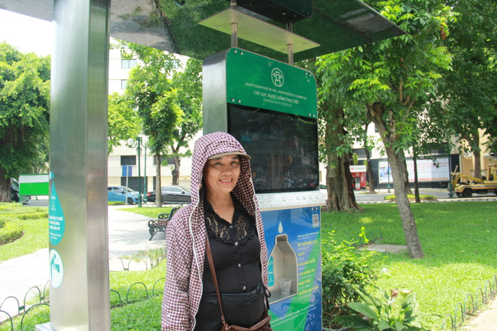 Hình ảnh người dân thích thú khi được sử dụng nước miễn phí tại cây lọc nước thông minh.