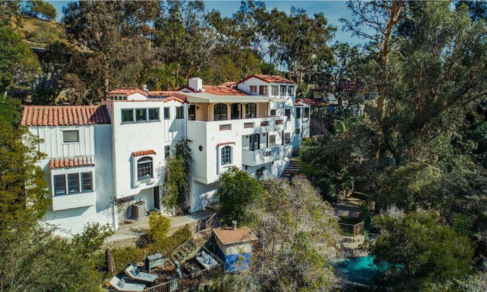 Biệt thự mang phong cách Địa Trung Hải này được xây vào năm 1938 và đã thay đổi trong những năm qua. Khi các nhà biên kịch Hollywood, Roger Simon và Sheryl Longin sở hữu ngôi nhà, nó đã có mặt tiền sặc sỡ với các màu nâu, xanh lá và hồng. Nhưng trong lần sửa chữa mới đây nhất, nó đã được phủ trắng toàn bộ. Ảnh: Coldwell Banker Residential Brokerage.