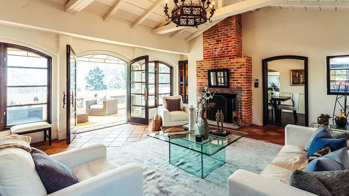 Biệt thự rộng khoảng 310 m2 với 4 phòng ngủ, 4 phòng tắm với những đường nét mang hơi thở Tây Ban Nha điểm xuyến. Trong ảnh là phòng khách với đèn chùm rực rỡ. Ảnh: Coldwell Banker Residential Brokerage.