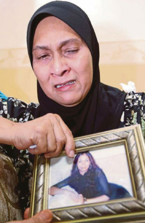 Mẹ của nữ tiếp viên Nur Shazana Binti Mohamed Salleh bên cạnh di ảnh của người con.