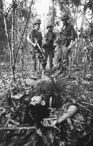 Binh sĩ Mỹ kiểm tra thi thể một người chết trận trong cánh rừng.