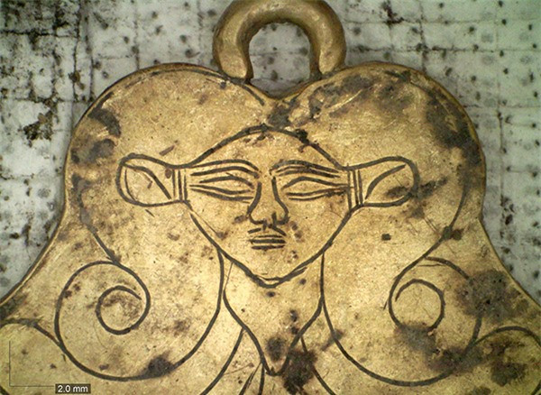 Mặt dây chuyền bằng vàng chạm khắc khắc hình đầu của nữ thần Ai Cập cổ đại Hathor. Hai ngôi cổ mộ này được phát hiện bởi cặp vợ chồng Jack L. Davis và Sharon R. Stocker - các chuyên gia khảo cổ học tại Đại học Cincinnati, những người đã nghiên cứu địa điểm này từ năm 1992. Cũng chính họ đã phát hiện ra ngôi mộ Chiến binh Griffin chứa kho báu và nhiều đồ trang trí trong đó vào năm 2015.