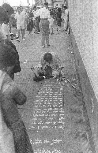 Người vô gia cư xin ăn trên vỉa hè, được người đi đường chú ý và giúp đỡ.