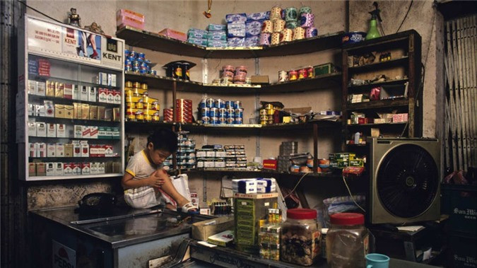 ##sc### Hình ảnh bên trong một tiệm tạp hóa ở Cửu Long Thành Trại. Bất chấp vẻ ngoài tồi tàn, người dân nơi đây vẫn tìm được cách mưu sinh và tồn tại. Nhiếp ảnh gia Greg Girard khi chụp các bức ảnh đã nhận xét: "Mọi người đều làm việc bình thường, chỉ có điều họ làm trong một nơi phi thường."