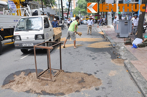 Công nhân của công ty Điện lực đã mang cát rải lên phần mặt đường có dầu nhớt tràn ra để tránh trường hợp người đi đường bị trượt ngã.