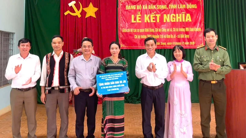 Đồng chí Phó Bí thư Thường trực Đảng ủy xã và đại diện các chi bộ trao tặng quà cho Nhân dân bon Bu Jri.