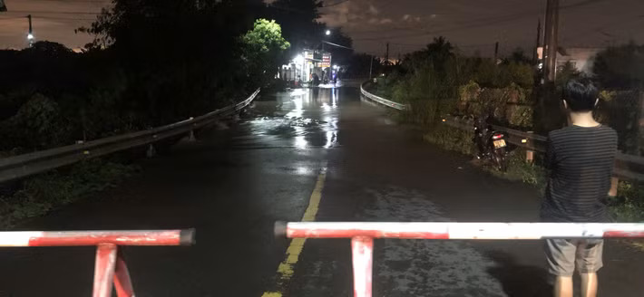 Cầu Tràn, phường Bình Thuận bị nước lũ chia cắt hoàn toàn, chính quyền lập rào chắn, cấm người và phương tiện qua lại.