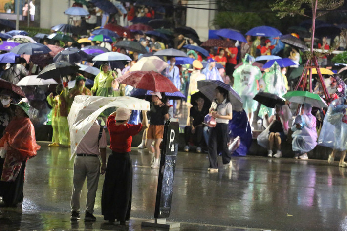 Mưa trút xuống càng thêm nặng hạt nhưng không vì thế mà làm giảm tinh thần "vượt nắng, thắng mưa" chờ xem diễu binh của người dân.