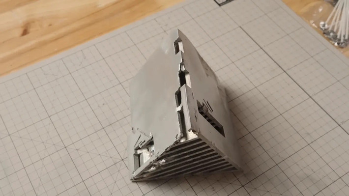 Sau khi lấy được bộ tản nhiệt từ thiết bị đúc sáp, nó vẫn cần một chút hoàn thiện, và XNZ phải tháo bỏ giá đỡ dùng để đổ khuôn. Khối tản nhiệt trông không quá cao cấp, nhưng điều đó không quan trọng vì nó sẽ không tiếp xúc trực tiếp với bo mạch chủ; nhiệm vụ đó vẫn thuộc về các tấm đồng, có nhiệm vụ phân tán nhiệt đều.