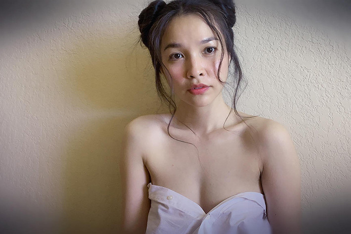 Nữ ca sĩ Hiền Thục quấn áo sơ mi, khoe vòng một hờ hững và búi tóc Na Tra trong loạt mới nhất.