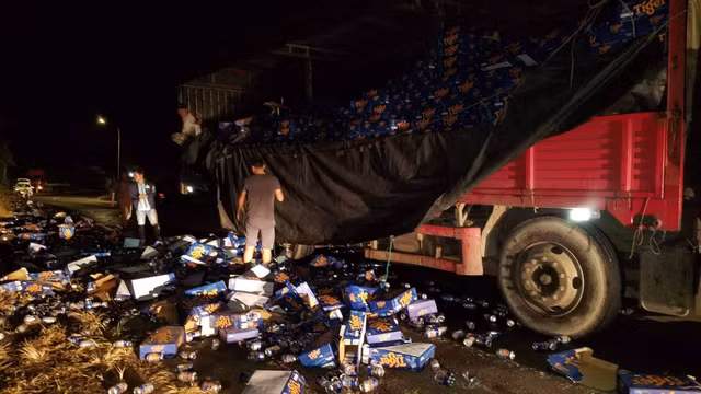 Tai xe container ngoi khoc khi hang tram thung bia do ra duong, nhieu nguoi toi thu gom giup-Hinh-2