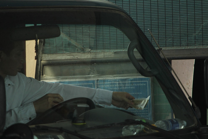 Tài xế chủ động đưa tiền cho nhân viên trạm để mua vé. Mức phí thấp nhất là 10.000 đồng/xe 4 chỗ ngồi.