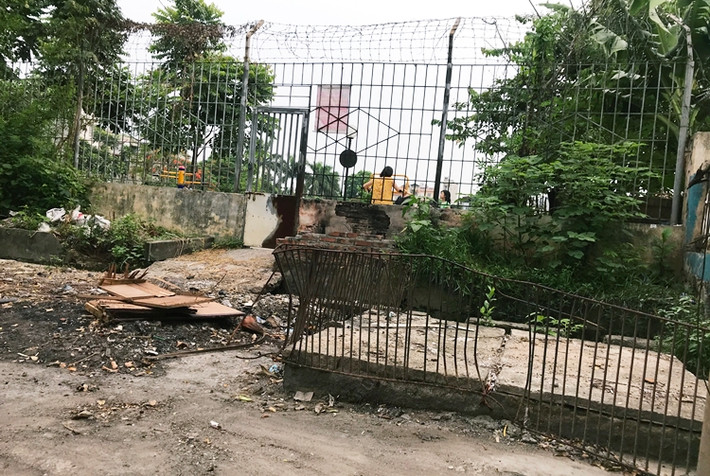 Khu đất được ngăn cách với bên ngoài bằng hàng rào sắt dựng cao.