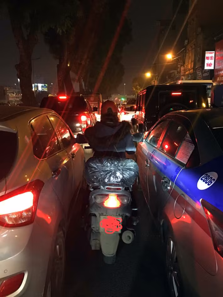 Xe máy nhọc nhằn, luồn lách qua "kẽ hở" mà ô tô "thừa" lại trên đường Láng.