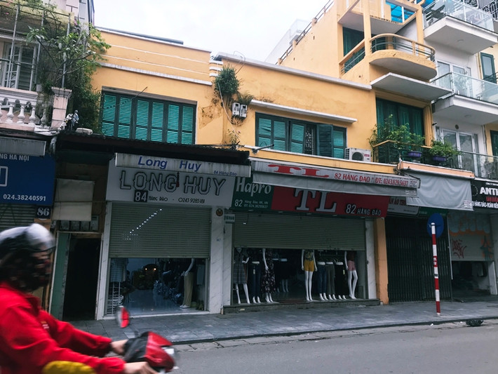 Một số cửa hàng thời trang trên phố Hàng Đào vẫn cố gắng mở hé nửa cánh cửa cuốn.