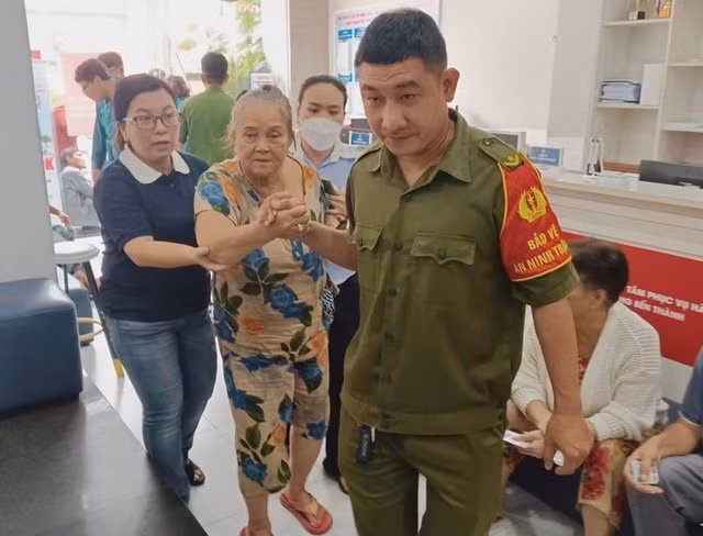 Nhân viên địa phương hỗ trợ người dân làm thủ tục nhận quà Tết Độc lập tại phường Bến Thành. Ảnh: HN