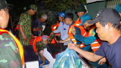 Bộ đội hỗ trợ người dân di chuyển ra khỏi khu vực ngập sâu lúc rạng sáng 5/12.