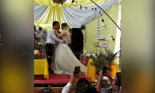 Chú rể chạm nhẹ môi cô dâu rồi liền lấy vai áo chùi miệng. Ảnh cắt từ clip.