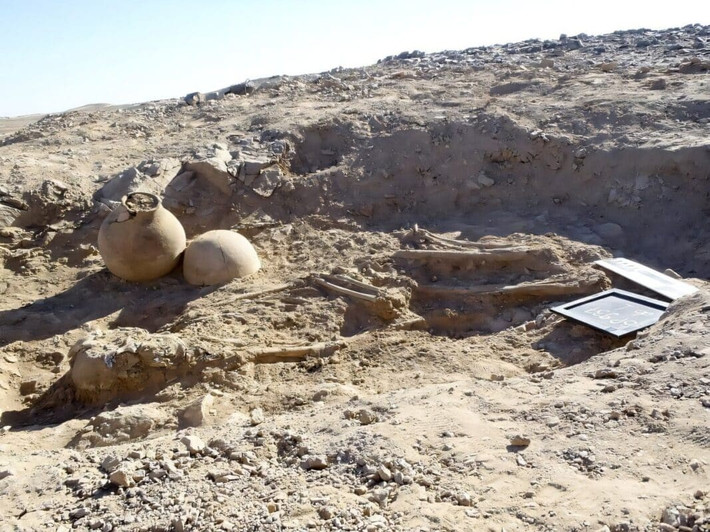 Bên trong ngôi mộ, với một gò đất hình bầu dục phía trên, các nhà khảo cổ đã phát hiện ra một bộ xương nam giới, 2 chiếc bình gốm đặt phía sau đầu và 82 hạt gốm hình đĩa tráng men xanh quanh cổ. Ảnh: A. Pudło in Badura et al. 2025.