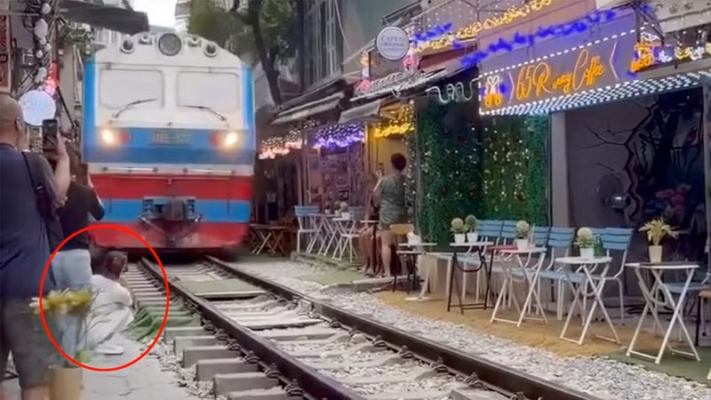 Ngồi sát đường ray quay tàu, cô gái suýt gặp họa trong gang tấc