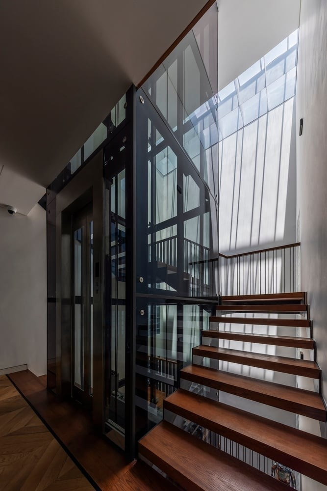 Cầu thang gỗ mộc mạc là điểm nhấn giữa không gian hiện đại. Ảnh: Hiroyuki Oki