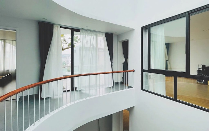 Cầu thang uốn lượn là điểm nhấn mềm mại, tạo sự kết nối giữa các tầng. Ảnh: NguyenhieuARC