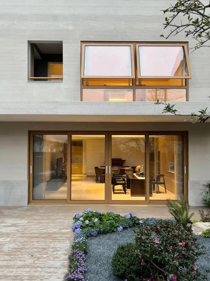 Căn biệt thự có mặt ngoài sơn trắng, bức tường sân ốp bằng ván gỗ ghép, tạo vẻ ngoài giản dị, gần gũi. Ảnh: Toutiao