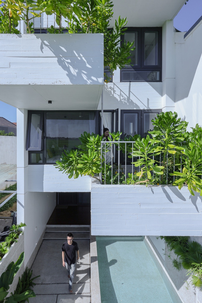 Ban công rộng trồng nhiều cây xanh, tạo thành một tấm rèm tự nhiên, vừa tạo điểm nhấn, lọc không khí vừa giúp che chắn bớt nắng gắt từ 9h sáng đến 3h chiều cho không gian bên trong. Ảnh: Sukha Studio.