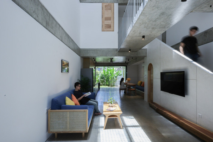 Phòng khách, khu bếp, bàn ăn được tổ chức liên tục, mở ra hai đầu sân vườn để đón gió và ánh sáng tự nhiên. Ảnh: Sukha Studio.