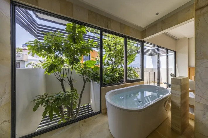 Phòng tắm trên tầng cao được bao quanh bởi nhiều cây xanh tươi mát. Ảnh: Oki Hiroyuki