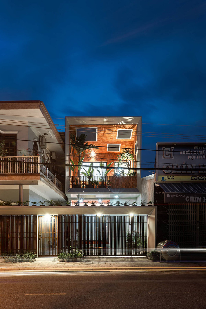 Bên cạnh đó, kiến trúc sư sử dụng bảng màu và tỷ lệ cửa sổ tương đồng với nhà cũ của ba mẹ, kết hợp hệ lam và cửa sắt sơn tĩnh điện màu đen chạy dài ngang mặt tiền để tạo nên một “mặt đứng liên tục”, giúp tổng thể công trình liền mạch về thị giác. Ảnh: Phan Trọng Tín - Minh Anh