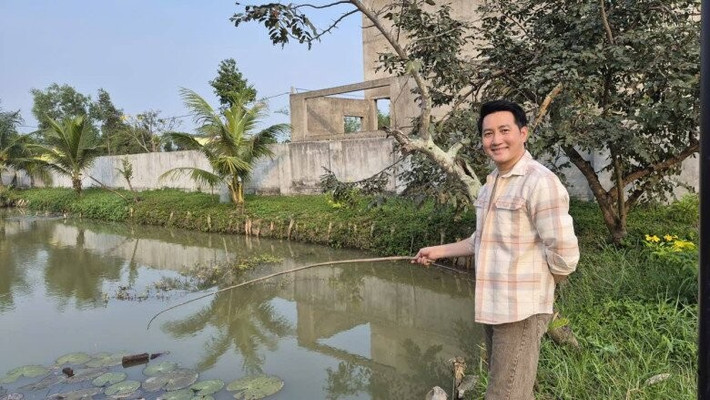 Ca sĩ Nguyễn Phi Hùng câu cá trong ao khi đến thăm nhà nam NSND. Ảnh: FBNV