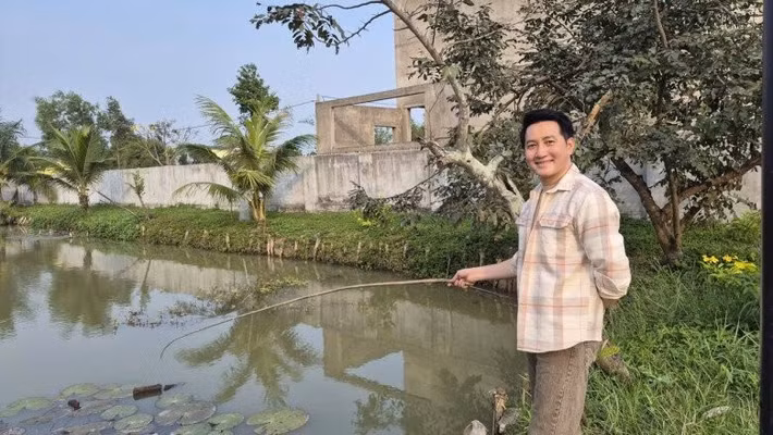 Ca sĩ Nguyễn Phi Hùng câu cá trong ao khi đến thăm nhà nam NSND. Ảnh: FBNV