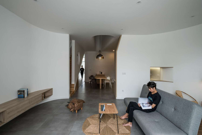 Thoạt nhìn, mặt tiền ngôi nhà khá ngột ngạt do phải xử lý che chắn theo ý muốn của gia chủ. Tuy nhiên, hệ thống cửa chớp gió ngang sẽ đưa luồng không khí trong lành từ bên ngoài vào trong nhà bằng chênh lệch áp suất tạo ra khi có giếng trời thẳng đứng lớn ngay chính giữa nhà. Ảnh: DinhR