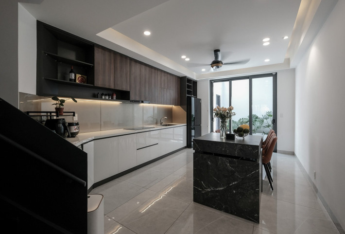 Phòng khách, phòng ăn và bếp được thiết kế liên thông, tạo sự liền mạch và thông thoáng. Ảnh: 3A Design