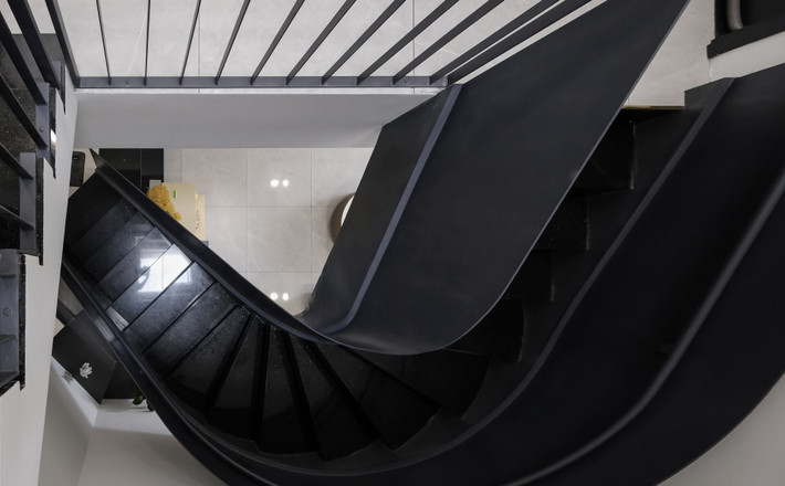 Cầu thang uốn tạo điểm nhấn đồng thời giúp không gian trở nên mềm mại. Ảnh: 3A Design