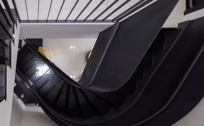 Cầu thang uốn tạo điểm nhấn đồng thời giúp không gian trở nên mềm mại. Ảnh: 3A Design