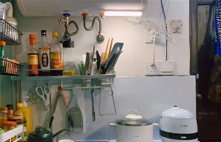 Khu bếp chật chội được sắp xếp gọn gàng với hệ tủ treo tường để chứa gia vị và đồ dùng nhà bếp. Ảnh: Toutiao