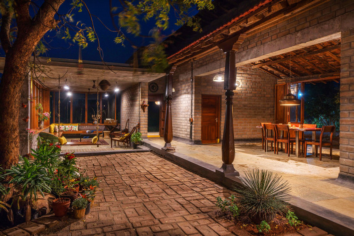 Nhìn từ bên ngoài, ngôi nhà như ẩn mình giữa vườn tược cỏ cây. Mong muốn của gia chủ là không gian sống gần gũi thiên nhiên và các hoạt động lao động hàng ngày. Ảnh: Ricken Desai